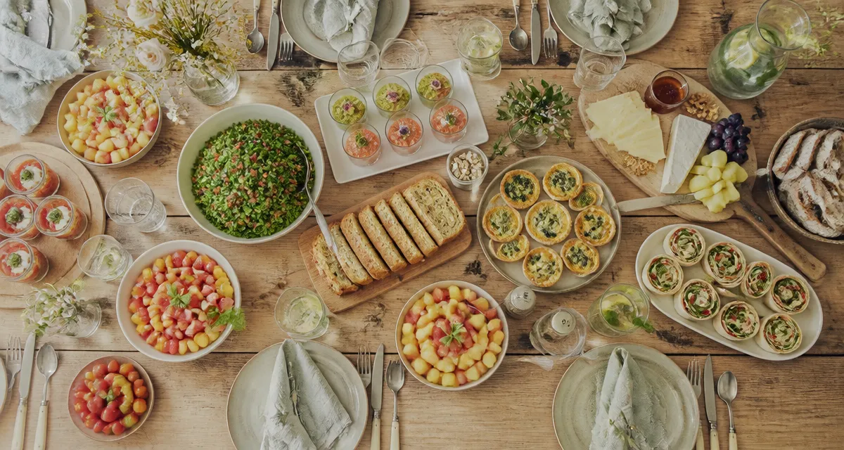 Repas froid entre amis sur grande table avec plats variés