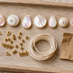Coquillages perles en nacre et coquillage naturel, apprêts dorés et cordon