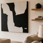 Décorer mur blanc avec grand tableau noir et étagères flottantes en chêne