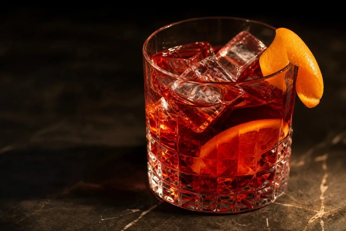 Recette negroni classique servie dans un verre Old Fashioned avec orange et glaçons