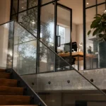 Mezzanine fermée vitrée avec verrière noire et porte coulissante lumineuse